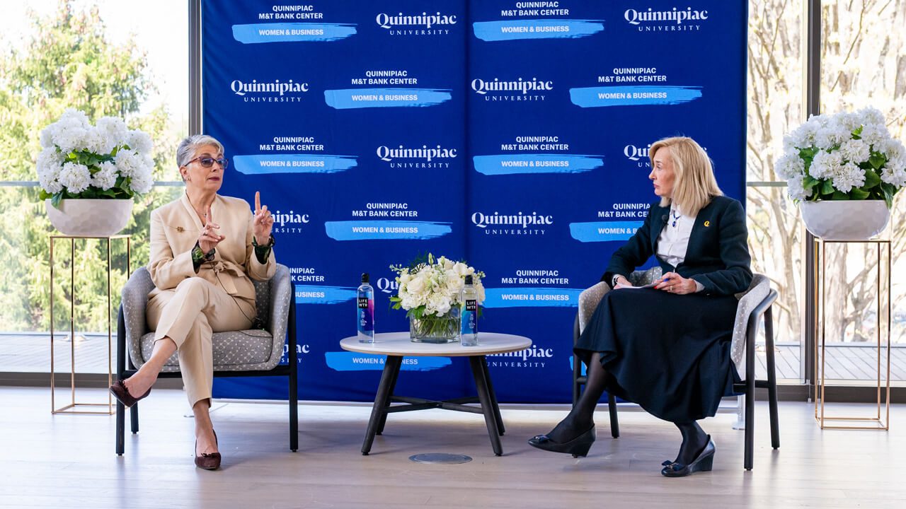 Fran Pastore speaks during the fireside chat in a chair next to President Hardin.