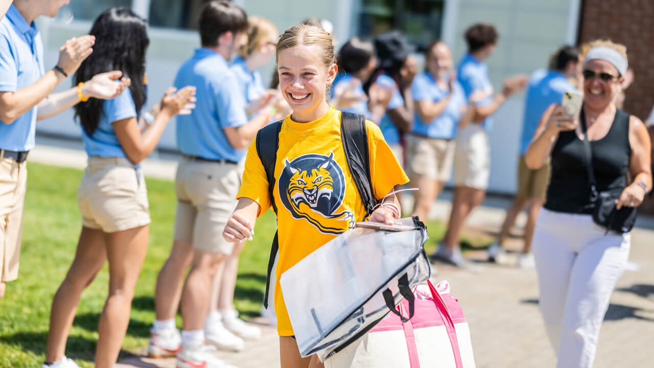 Student walks outside wearing yellow shirt