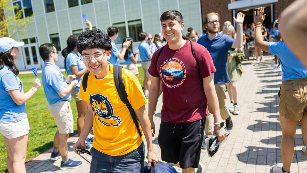 Students walk outside while smiling