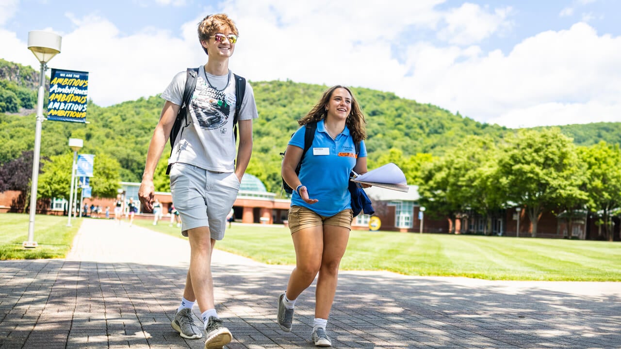 Two students walk on the quad