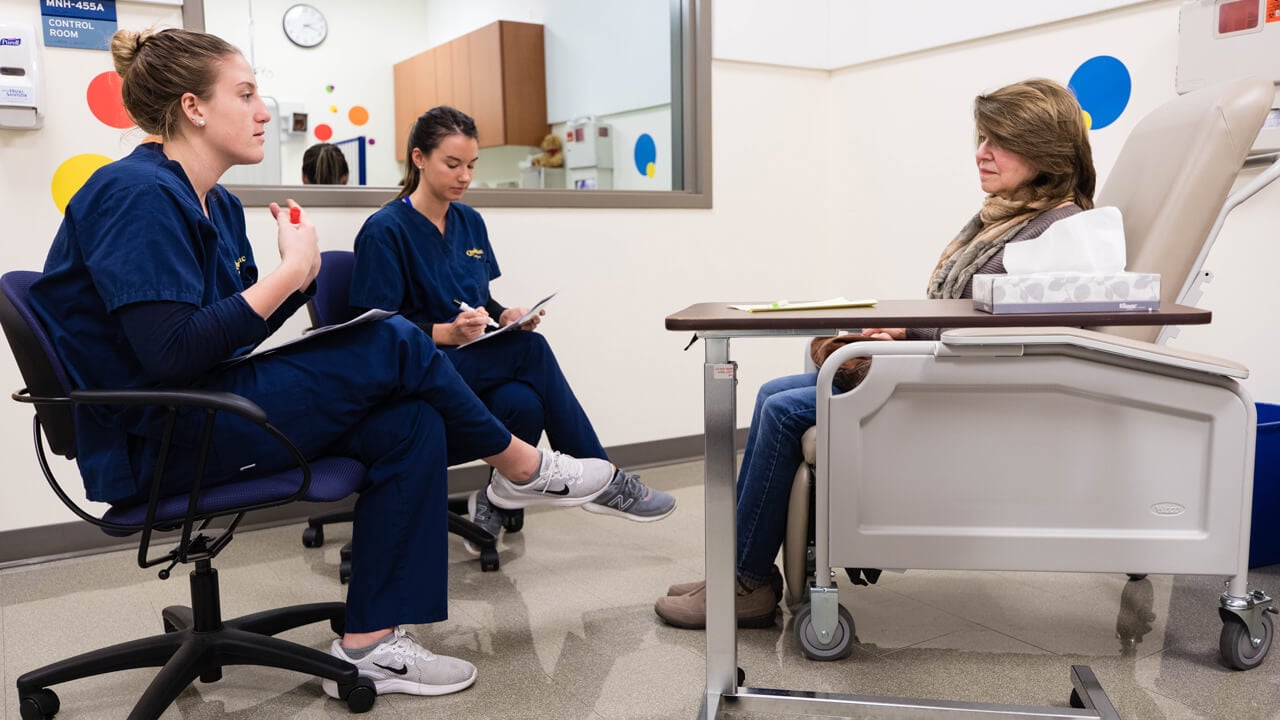 Quinnipiac Nursing students Jessica NIckerson, left, and Carolyn Fetchel, right, interact with a standardized patient.