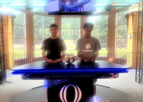 Sports communications campers stand with a soccer ball in Quinnipiac's Open Air Studio.