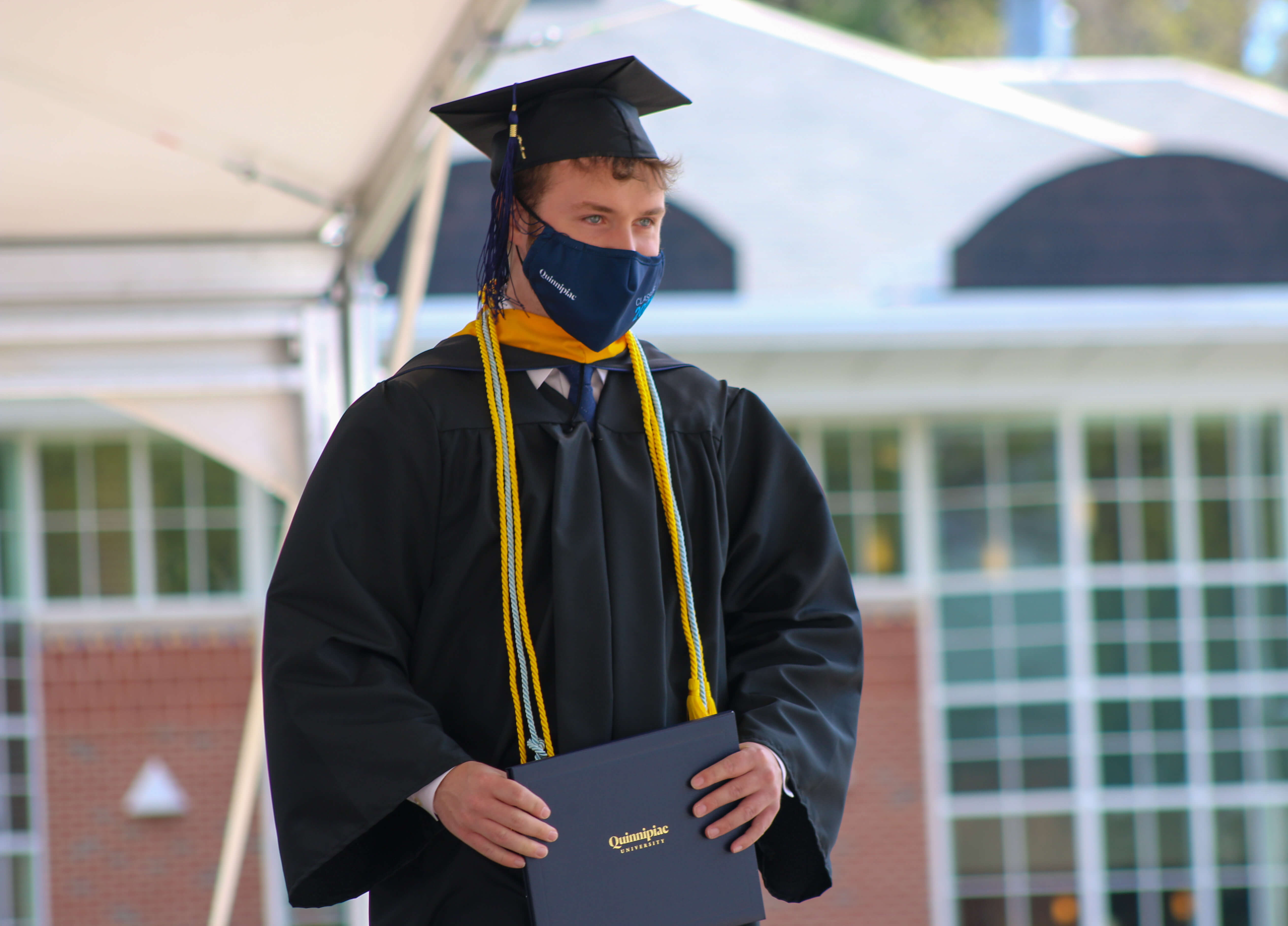 Alumnus Kyle Del Balso walking across the stage at commencement