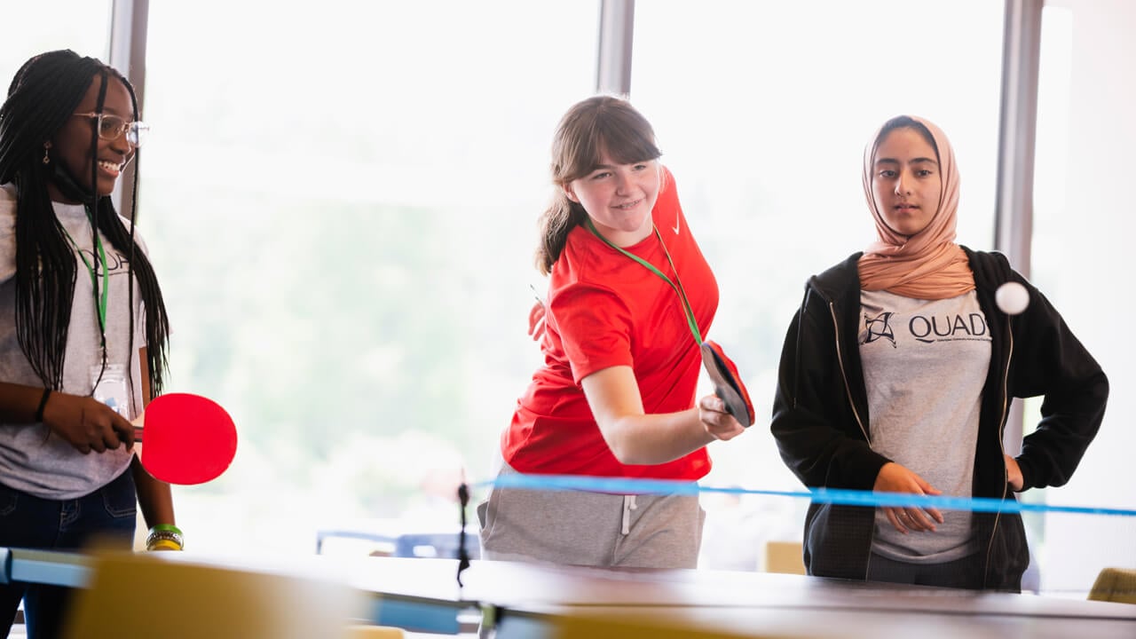 QUADS student plays ping pong with their mentor at the Quinnipiac North Haven campus.