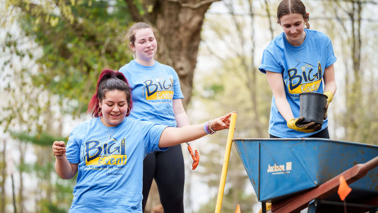 Students holding shovels and digging for the Big Event