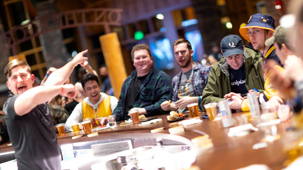 A row of students cheer during a men's ice hockey watch party