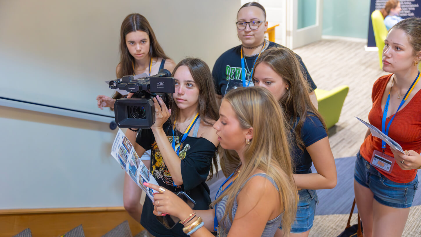 High school students collaborating to frame a shot on a UX-90 camera while consulting a shot list during Quinnipiac University’s Movie Making Summer Camp.