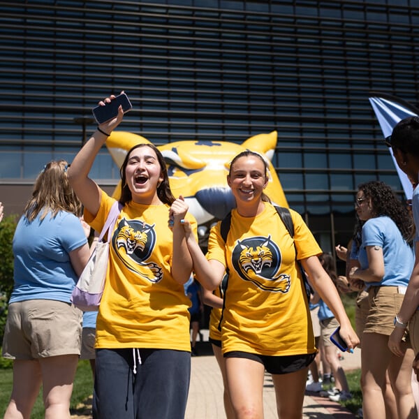 Two new students cheer in their Bobcat gold shirts during Orientation