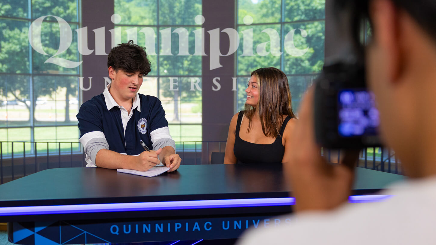 High school student Andrew Kiang photographs George Santoli (left) interviewing Madeline Crosby (right) during the Game Changers summer camp in the Open Air Studio.