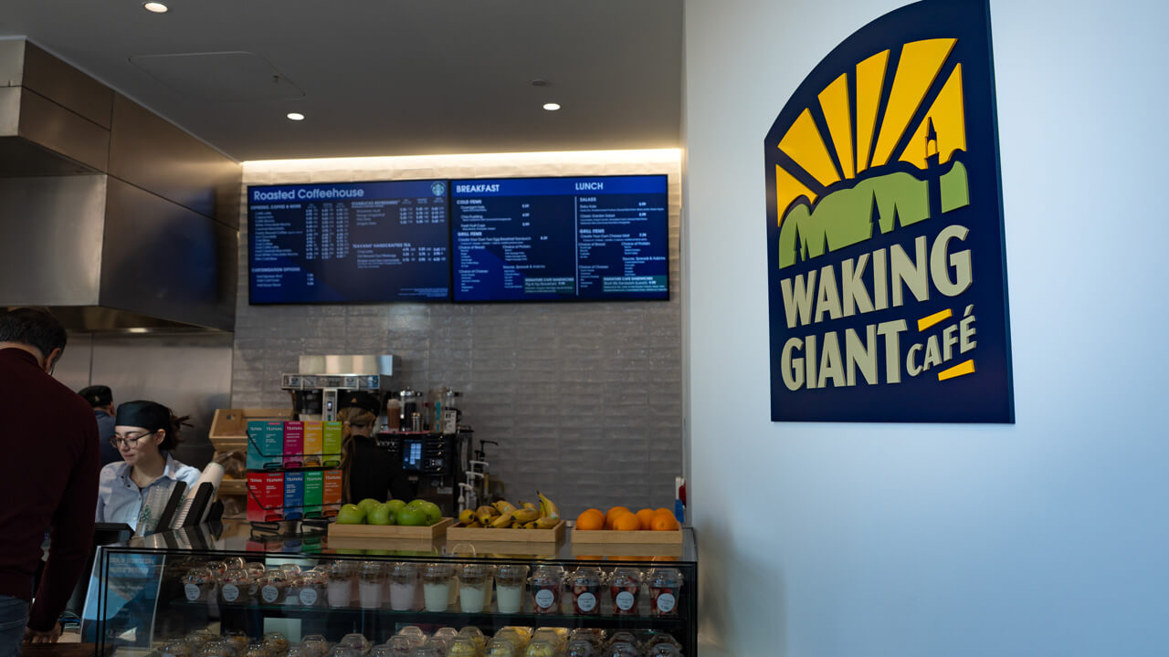 An image of the cash register area of Waking Giant Café, with the logo on the wall to the side.