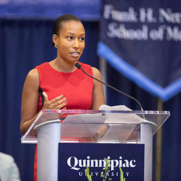 Kumba Hinds speaks from a podium during the White Coat ceremony