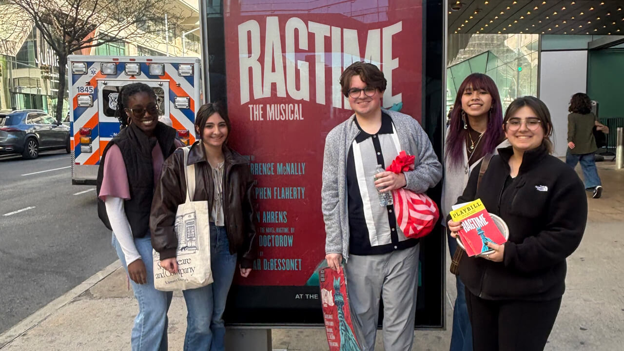 Five students stand in front of a board with a Ragtime The Musical graphic.