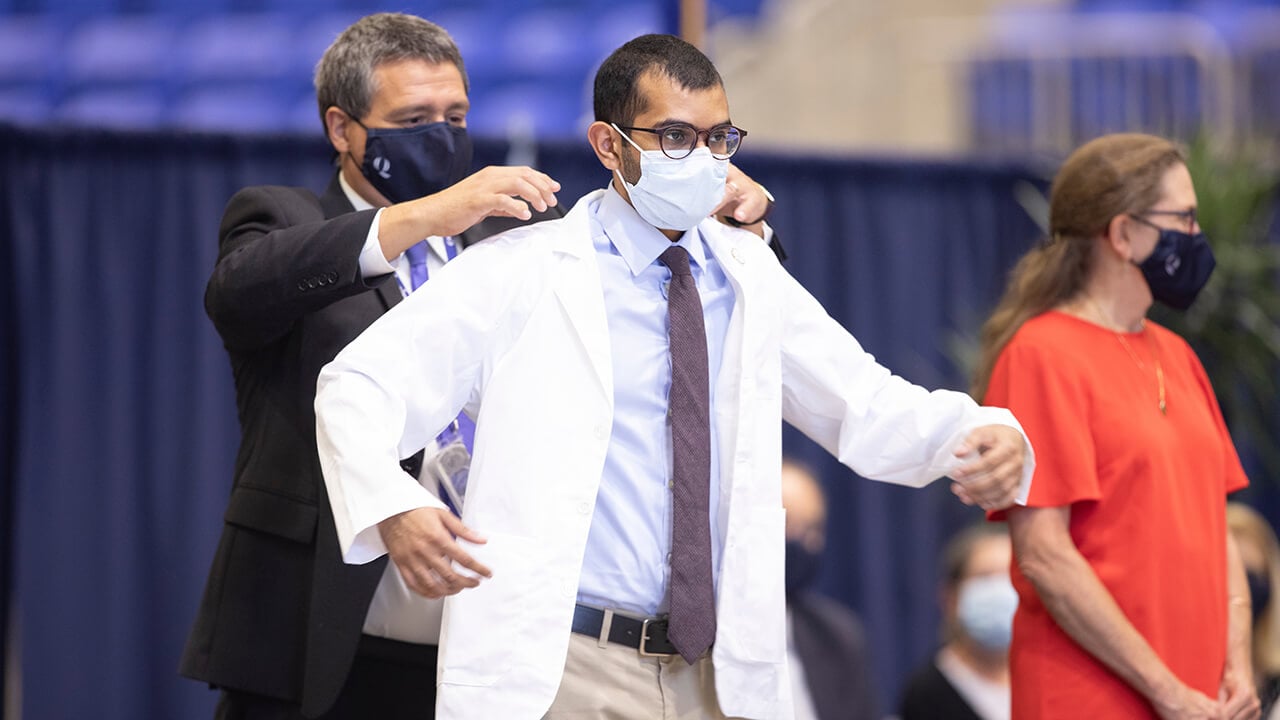 A student receives his white coat.