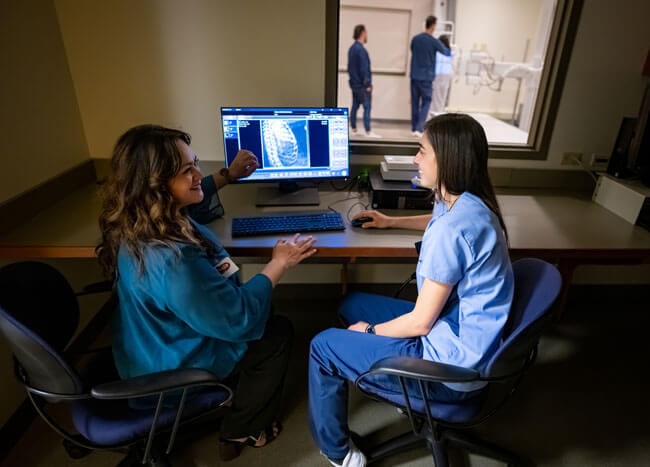 A professor of diagnostic imaging and program director of radiologic sciences, examines remains with students.