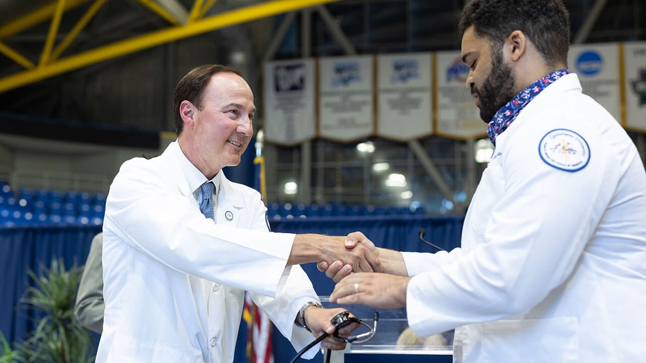 Student shakes hands with a faculty member