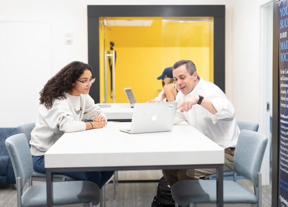 A student and career adviser work together in the Advising Commons