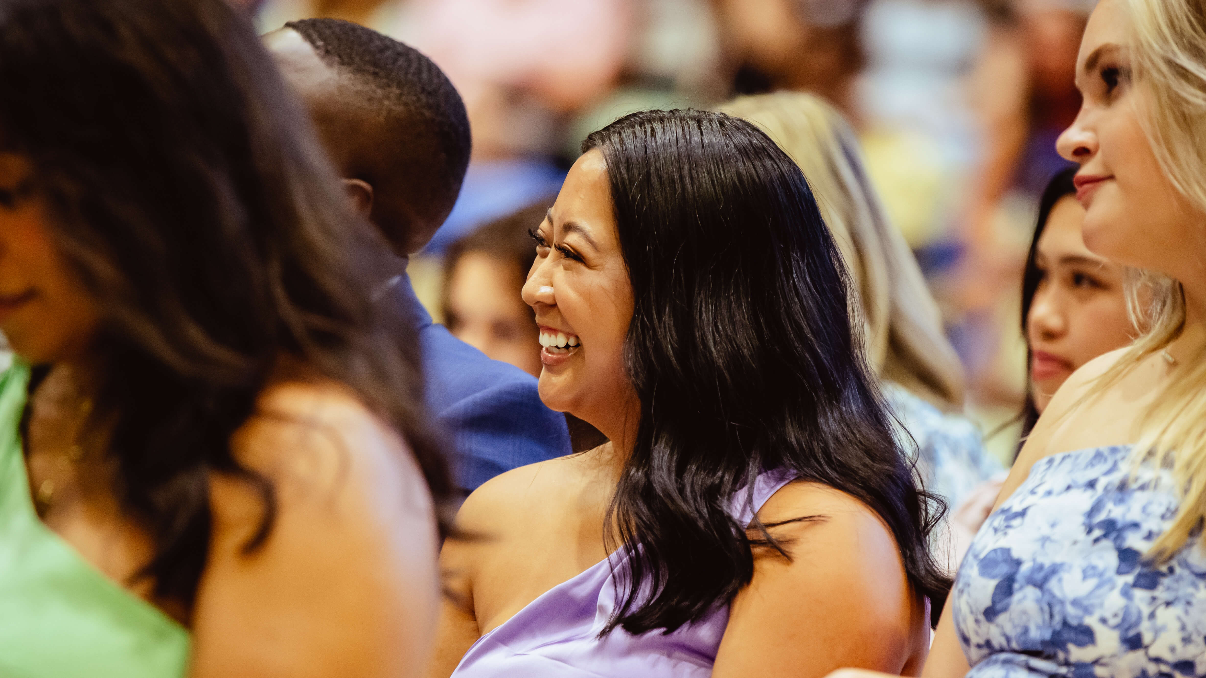 A graduate laughs in the crowd