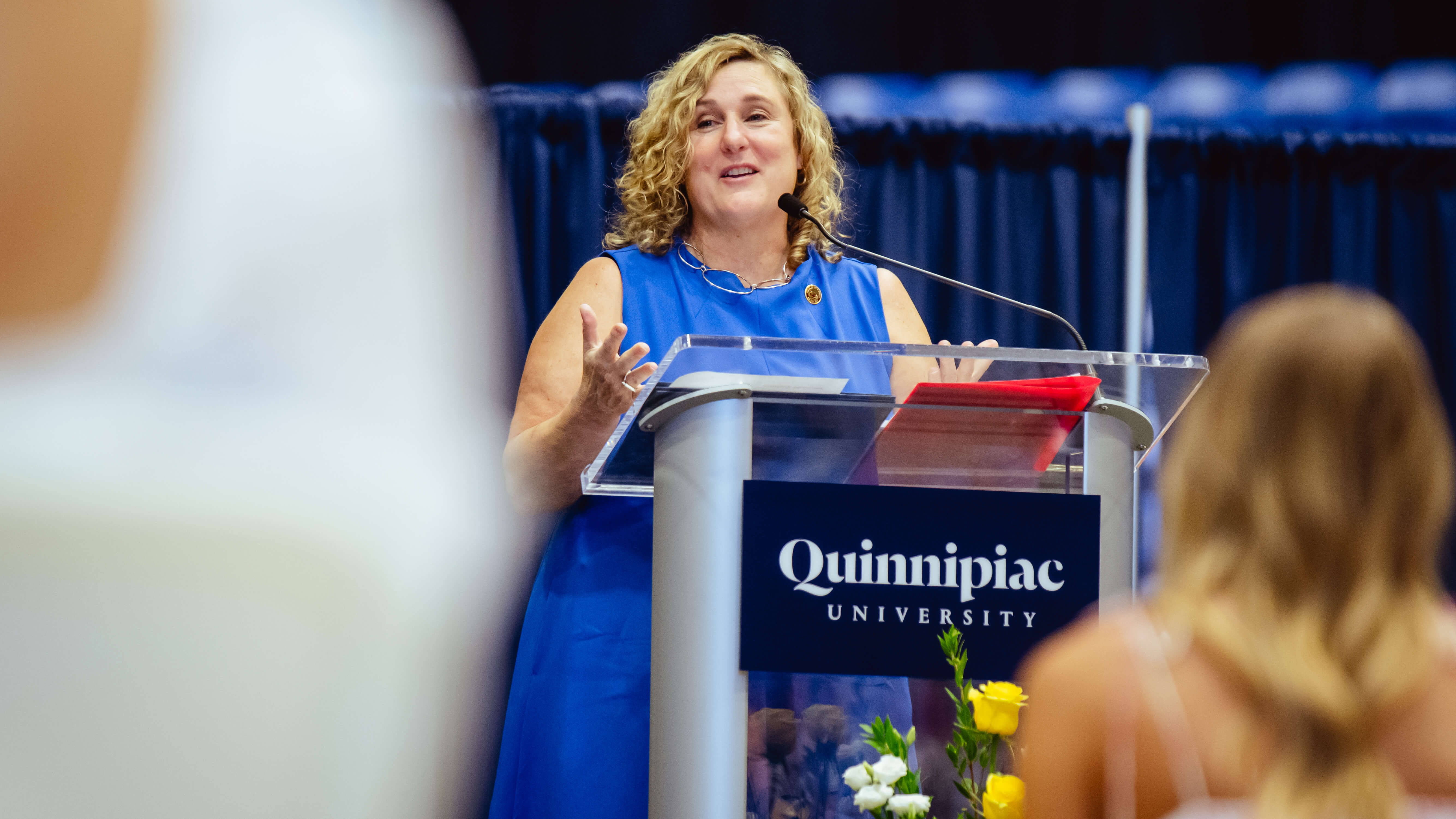 A speaker addresses the graduates and their families