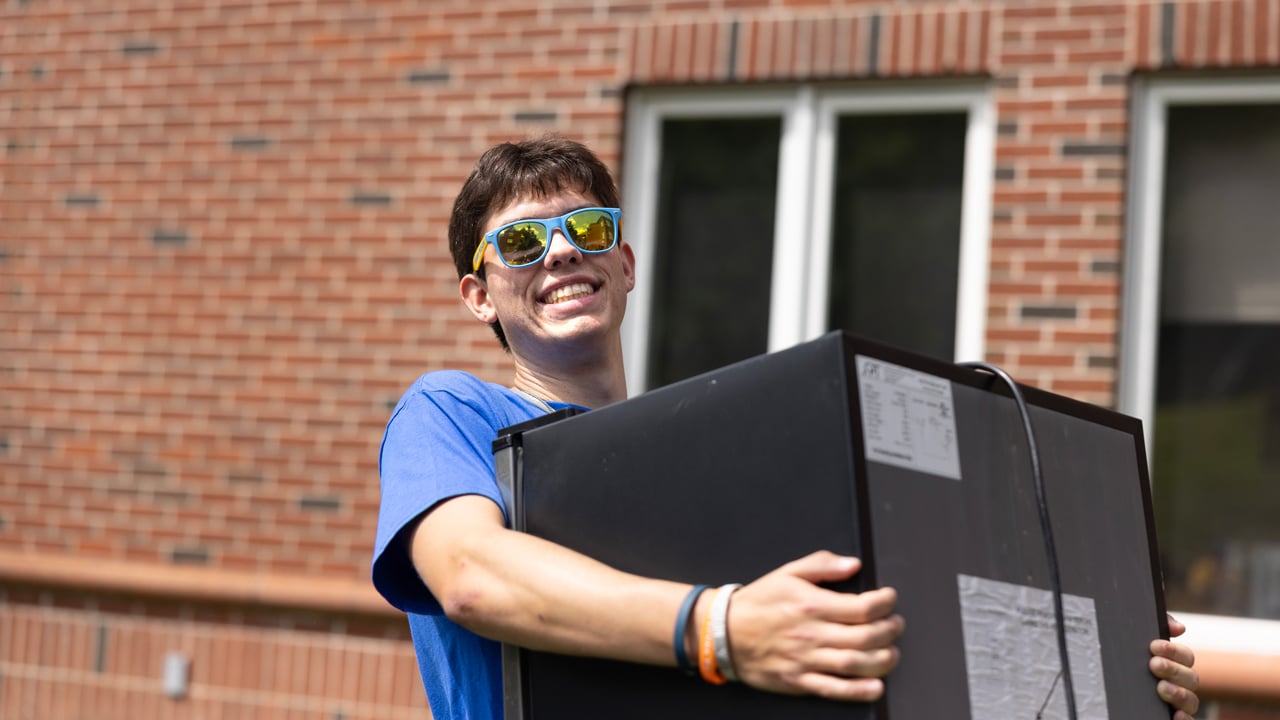 Student carrying a refrigerator