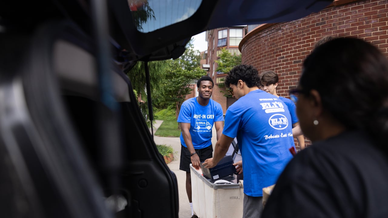 Students taking items out of trunk of a car