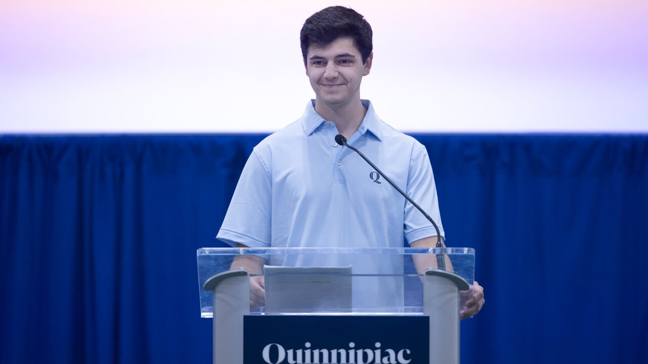 Student government association president Jake Cedor smiles from a podium