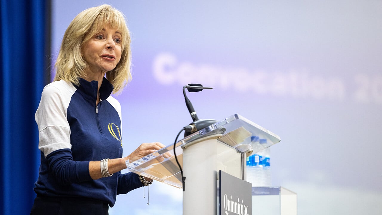 President Judy Olian at a podium.