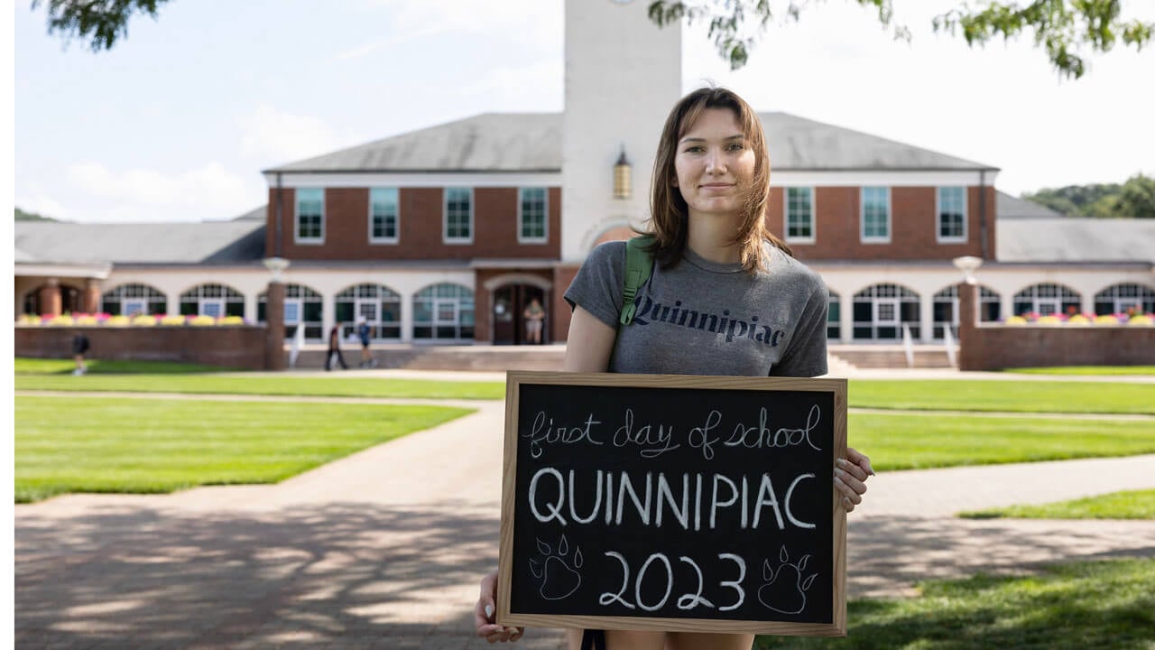 An excited student takes a photo on the Quad