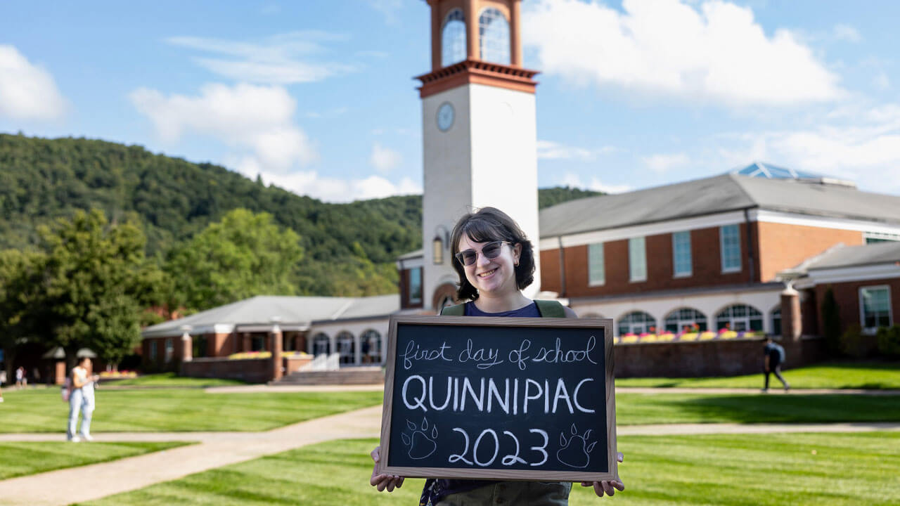 A student holds a first day of school sign