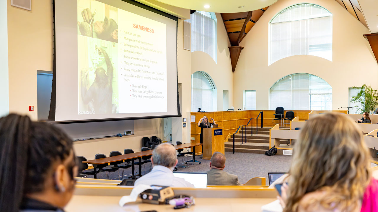 A woman presenting to lecture to a crowd