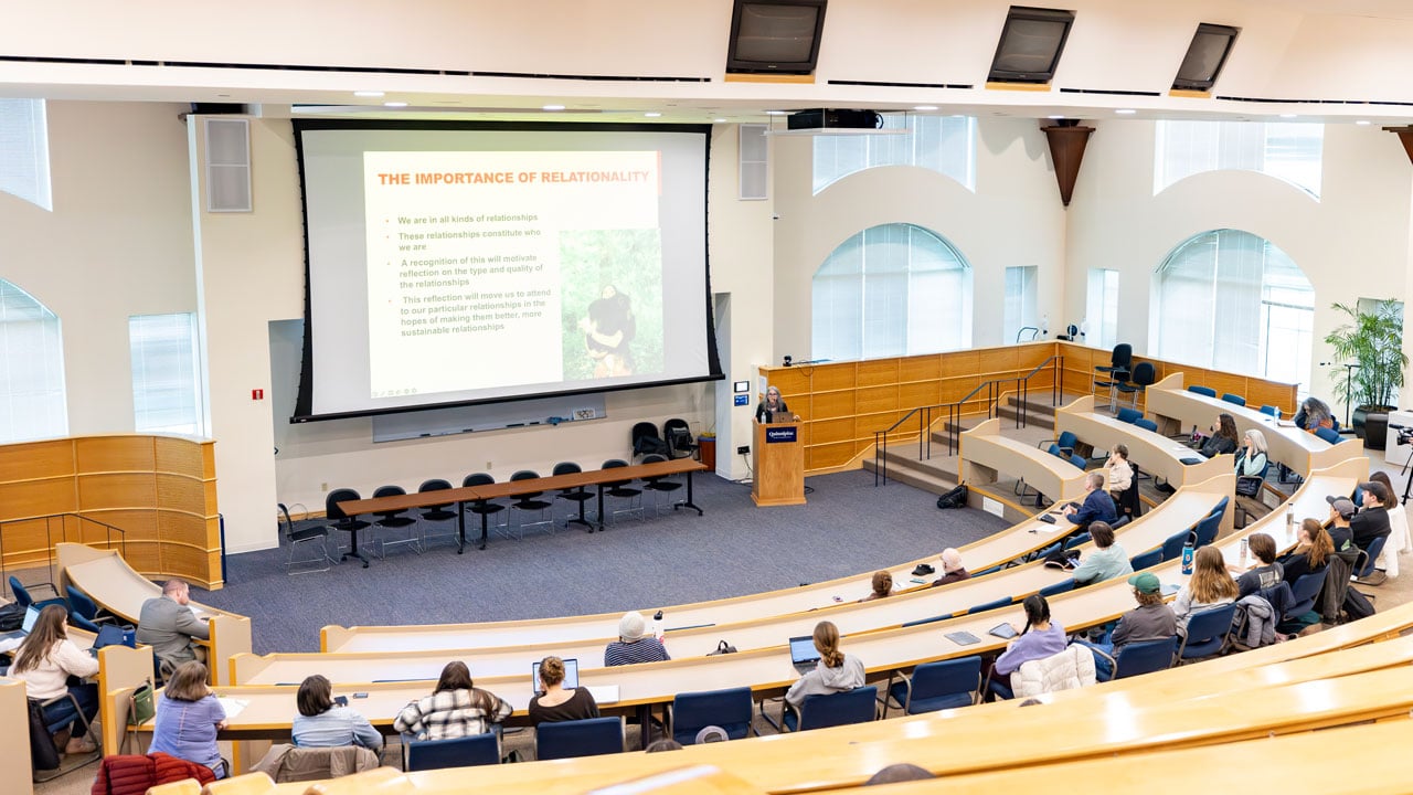 A woman presenting to lecture to a crowd