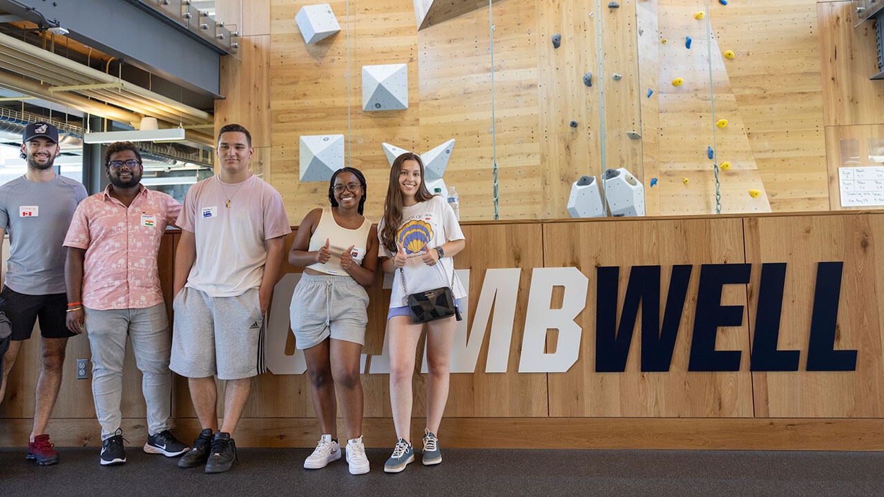 International students take a photo by the new rock wall