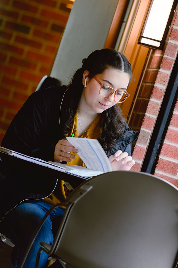 A female student flipping through a textbook