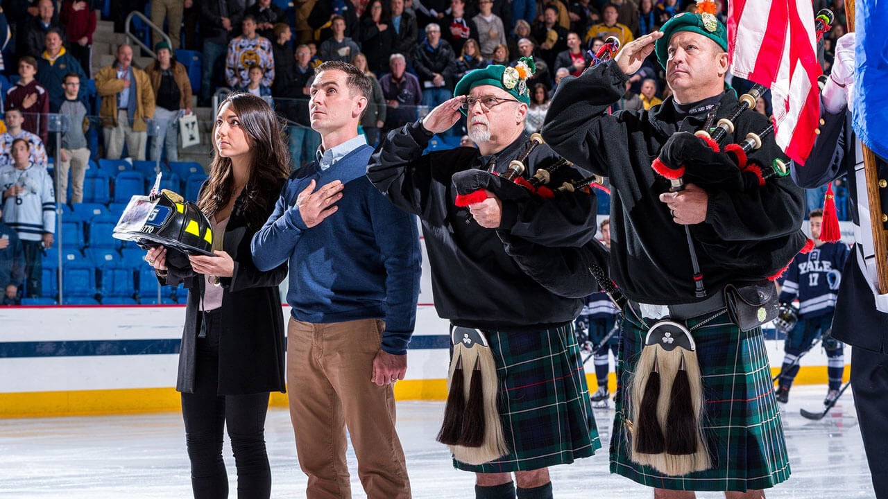 The Mascali family salute the flag on the ice at Quinnipiac.