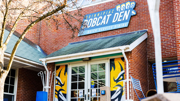 Outside Bobcat Den with the bright yellow and blue sign