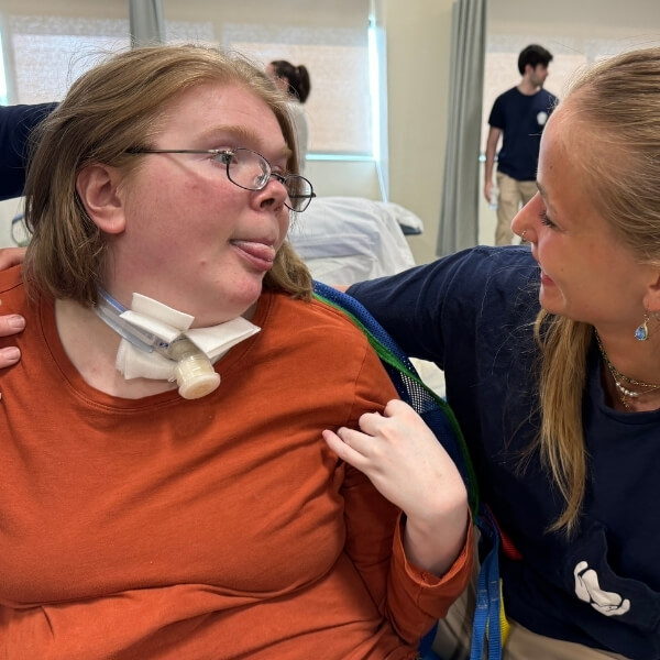 A photo of Cathy Hoder with a female students arm around her.