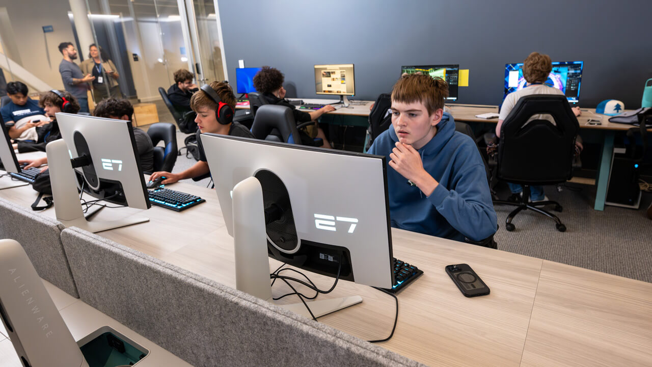 A row of students looking at monitors in the esports lab.