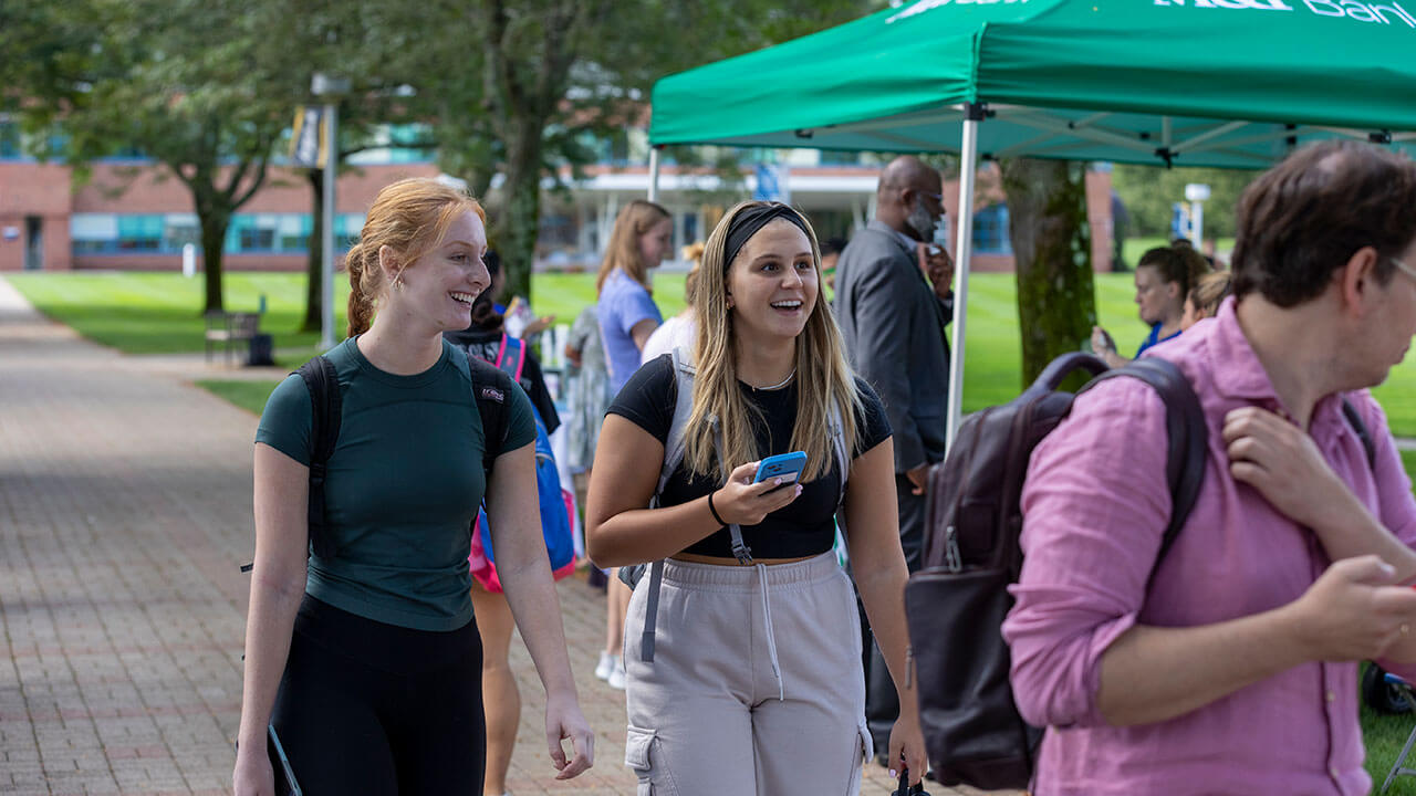 Two students smiling while walking through the Local Business Showcase