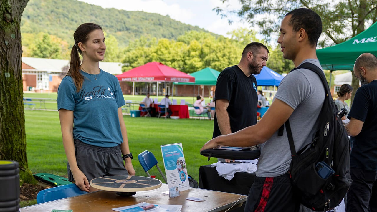 A fitness business explains their services to student