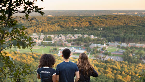 Three students from behind looking out at the view from the top of the Sleeping Giant