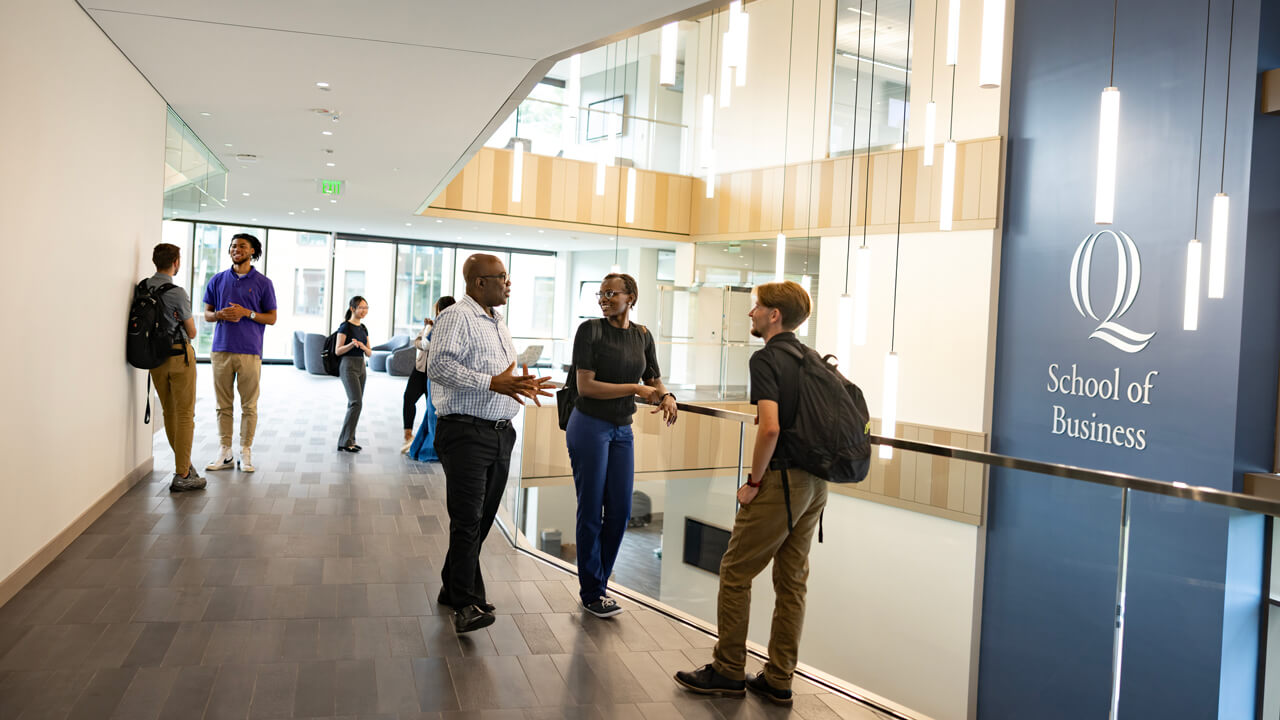 A group of students conversing on the second floor of the School of Business Atrium.