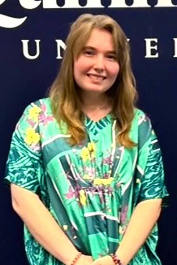 Headshot of Ava Real in front of a Quinnipiac banner.