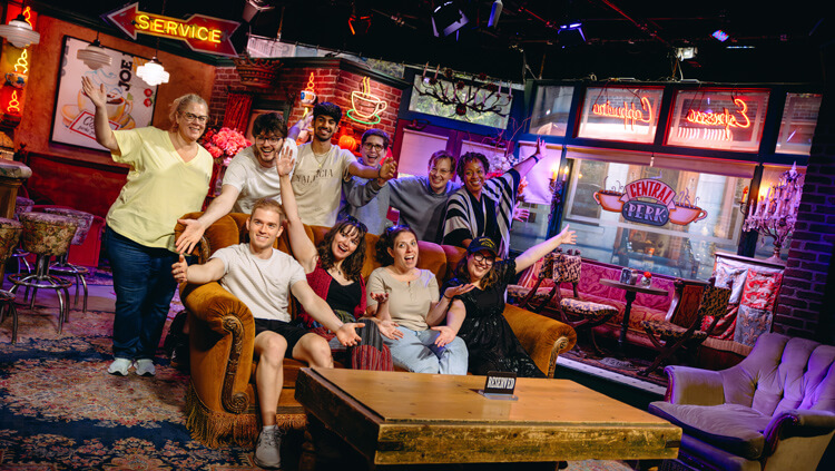 Quinnipiac faculty and students pose on the Friends couch during the Warner Bros studio tour.