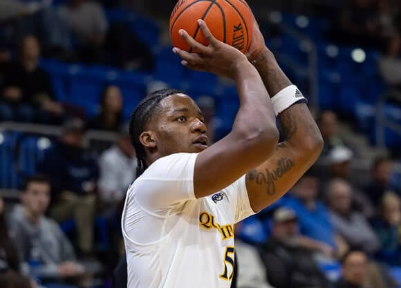 Quinnipiac basketball player throws ball upward.