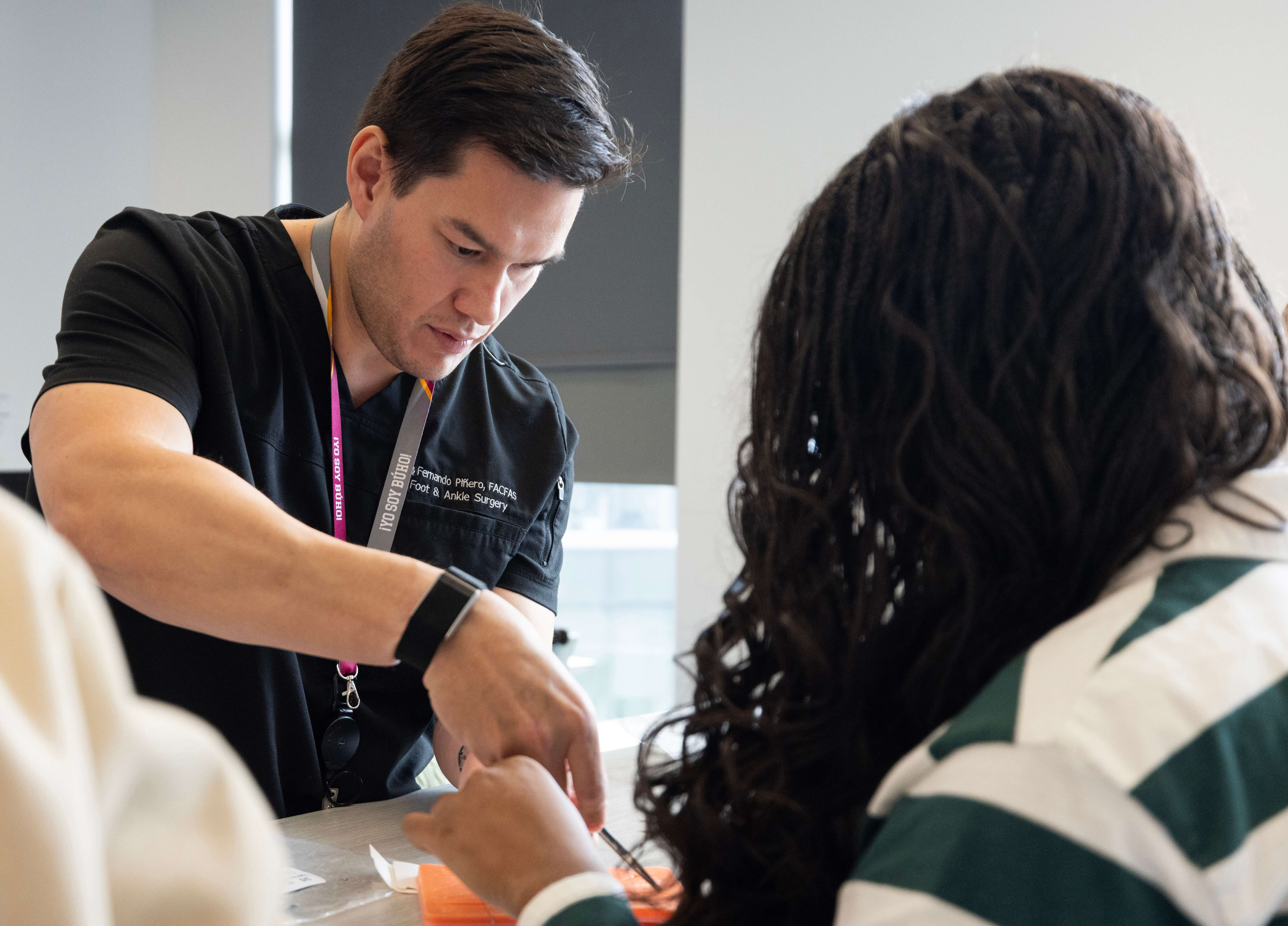 Health care professional performs task in black scrubs