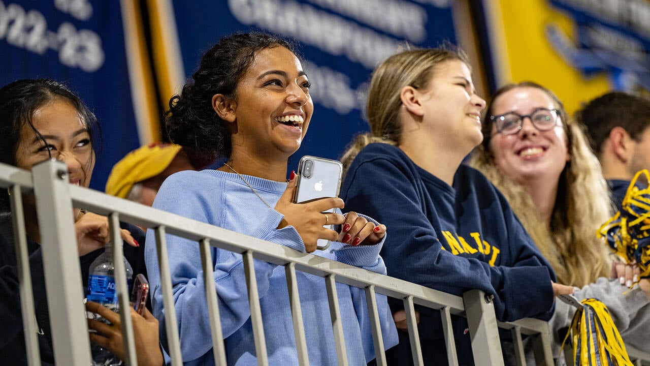 A student smiles during the banner raising