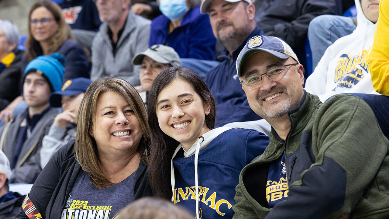 A family smiles for a photo during the banner raising