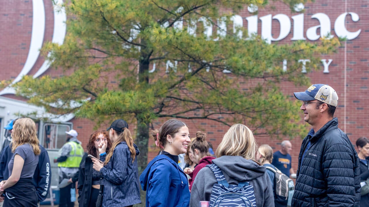 Student and parents laughing outside near food trucks