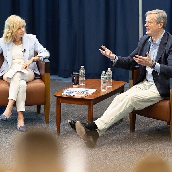 NCAA President Charlie Baker speaks with Quinnipiac President Judy Olian in leather armchairs