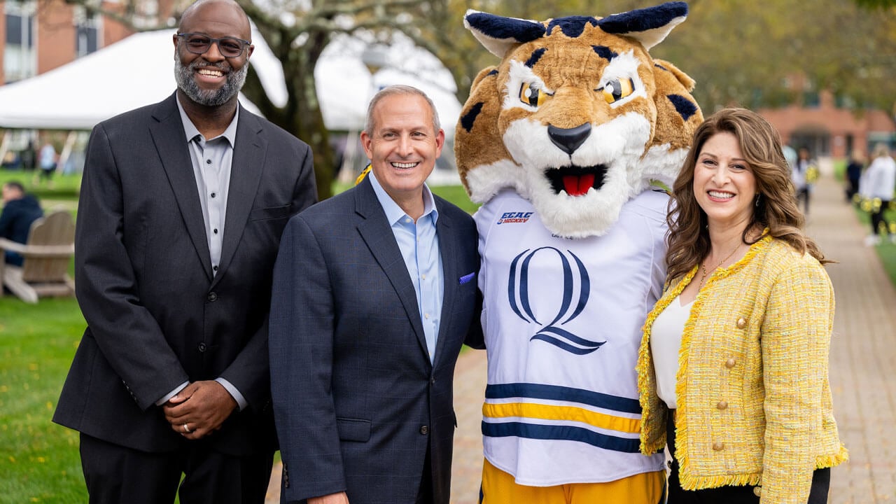 Faculty smile and take a photo with Boomer