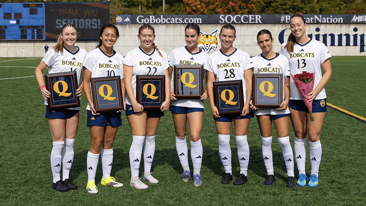 Women's soccer holding up senior day awards.